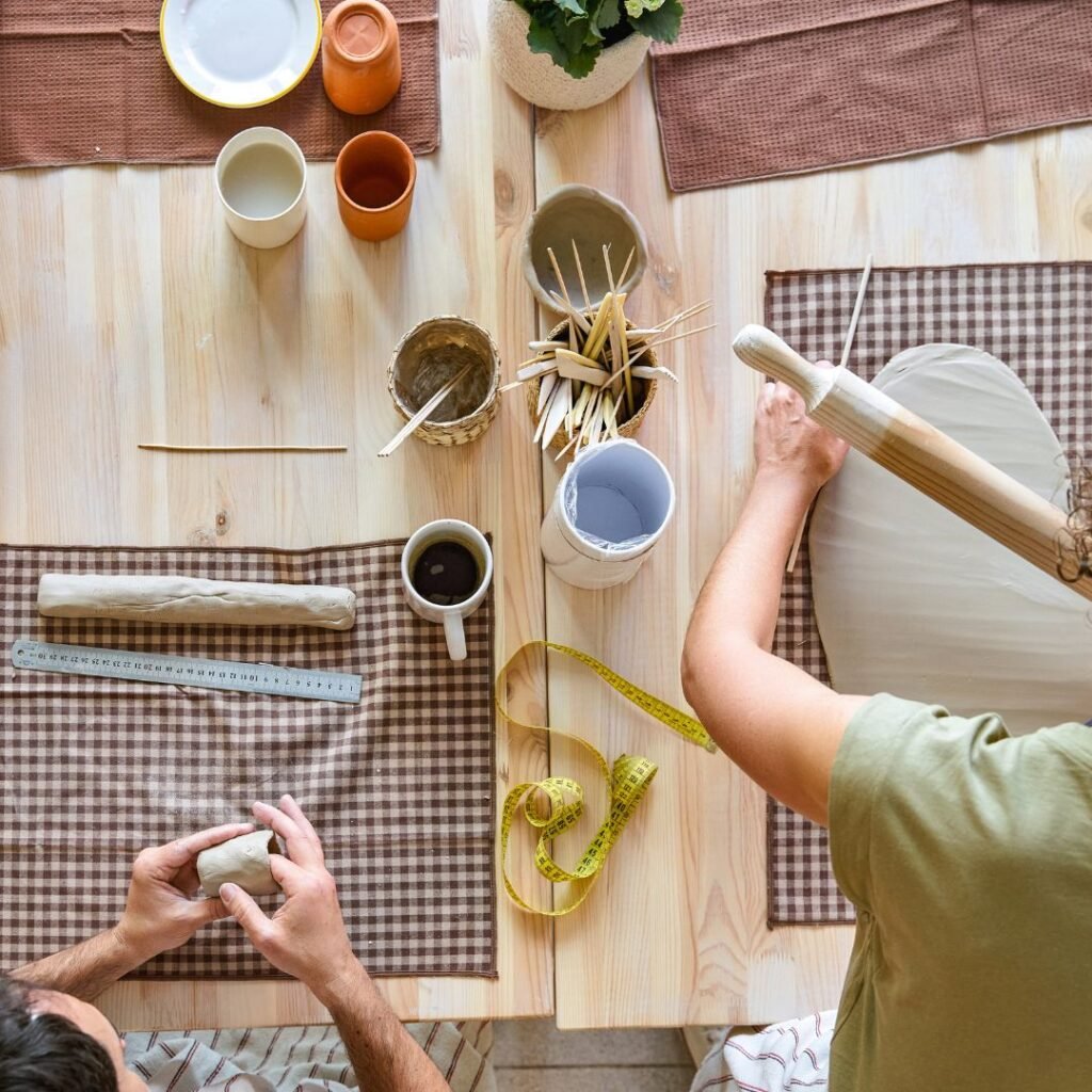 top view of people working with clay in pottery